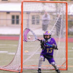 A lacrosse goalie catching a ball.